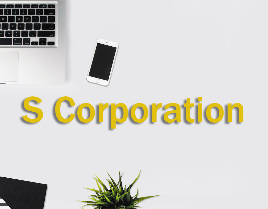 S corporation business entity written on desk with phone and laptop